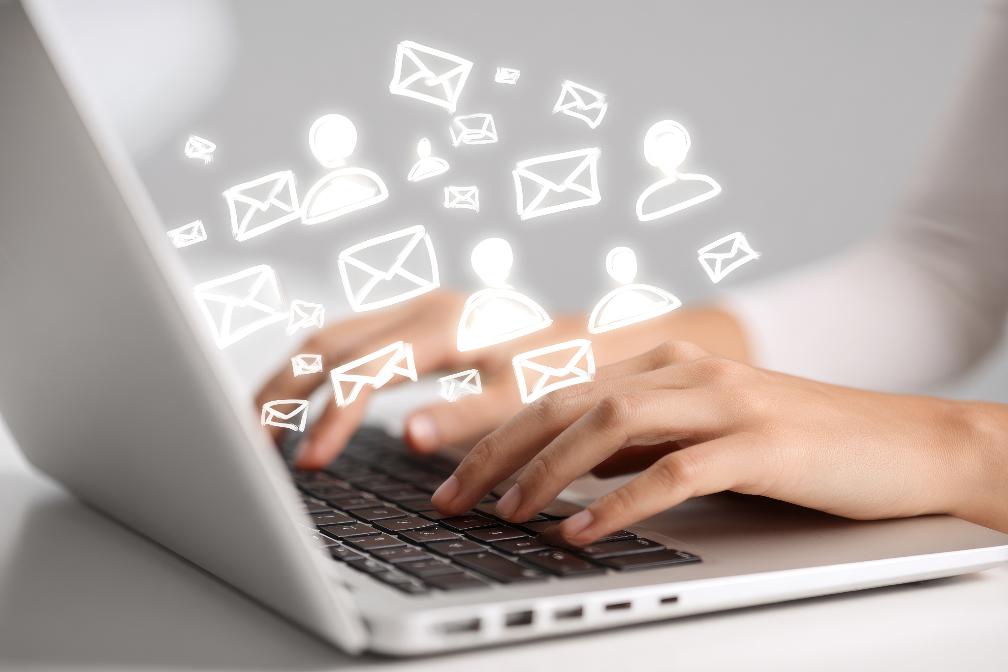 Hands typing on a laptop keyboard with illustrated email and contact icons overlaid above it.